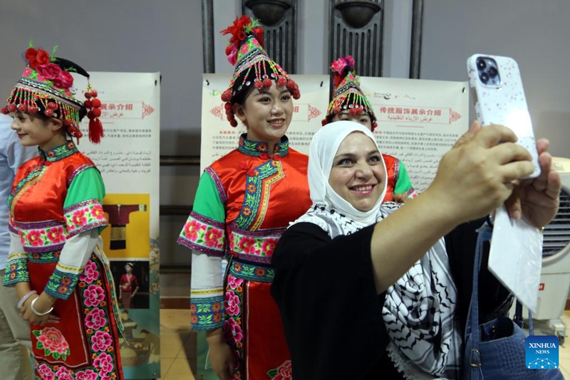 Mshiriki wa shughuli akijipiga selfie na waigizaji waliovalia mavazi ya kikabila kwenye Kituo cha Utamaduni wa China mjini Amman, Jordan, Juni 30, 2024. (Picha na Mohammad Abu Ghosh/Xinhua)